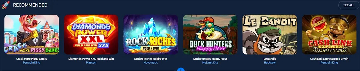 Recommended games carousel on a casino site showing tiles for Crack More Piggy Banks, Diamonds Power XXL Hold and Win, Rock Riches Hold and Win, Duck Hunters Happy Hour, Le Bandit, and Cash Link Express Hold and Win, with a “See All” button.