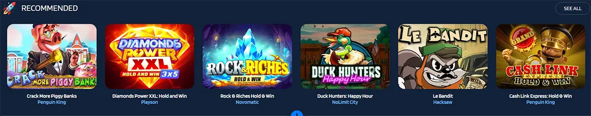 Recommended games carousel on a casino site showing tiles for Crack More Piggy Banks, Diamonds Power XXL Hold and Win, Rock Riches Hold and Win, Duck Hunters Happy Hour, Le Bandit, and Cash Link Express Hold and Win, with a “See All” button.